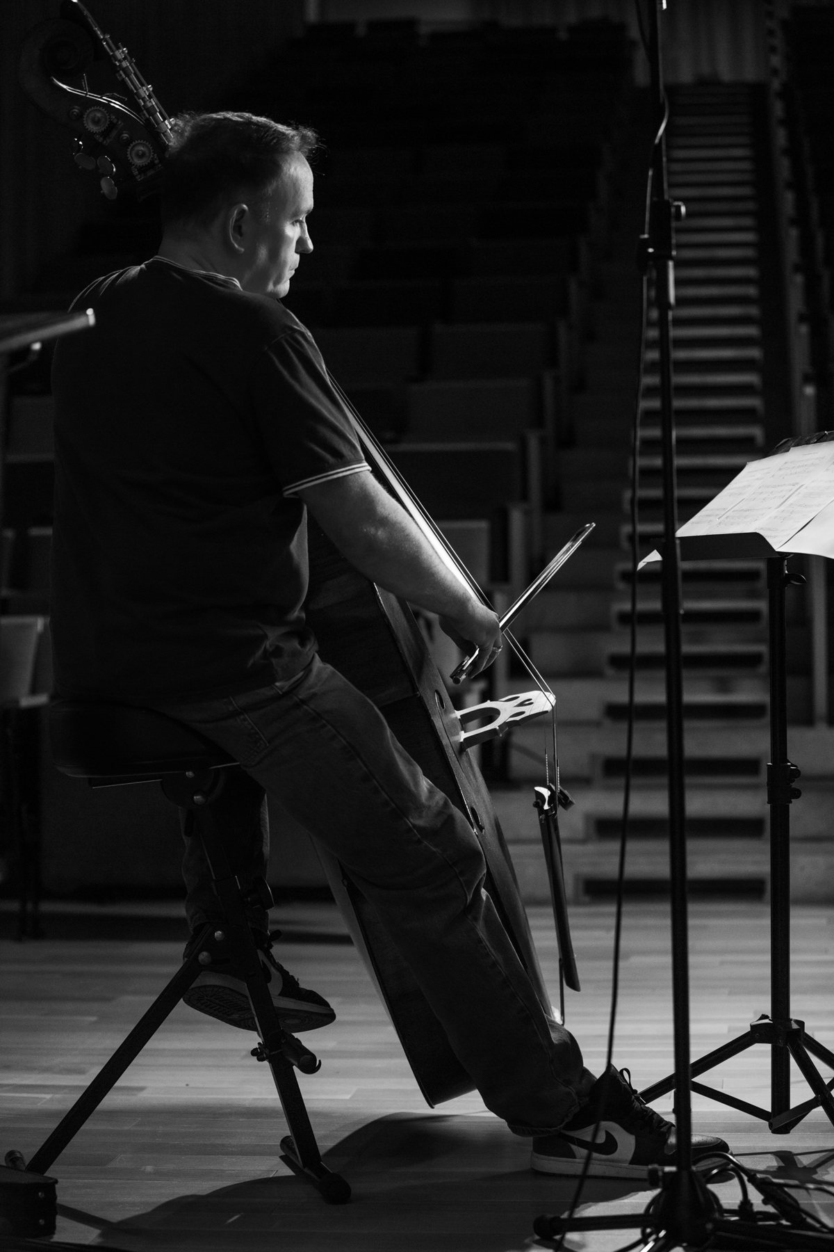 Rob Hutchinson seated at the double bass during a rehearsal, in profile
